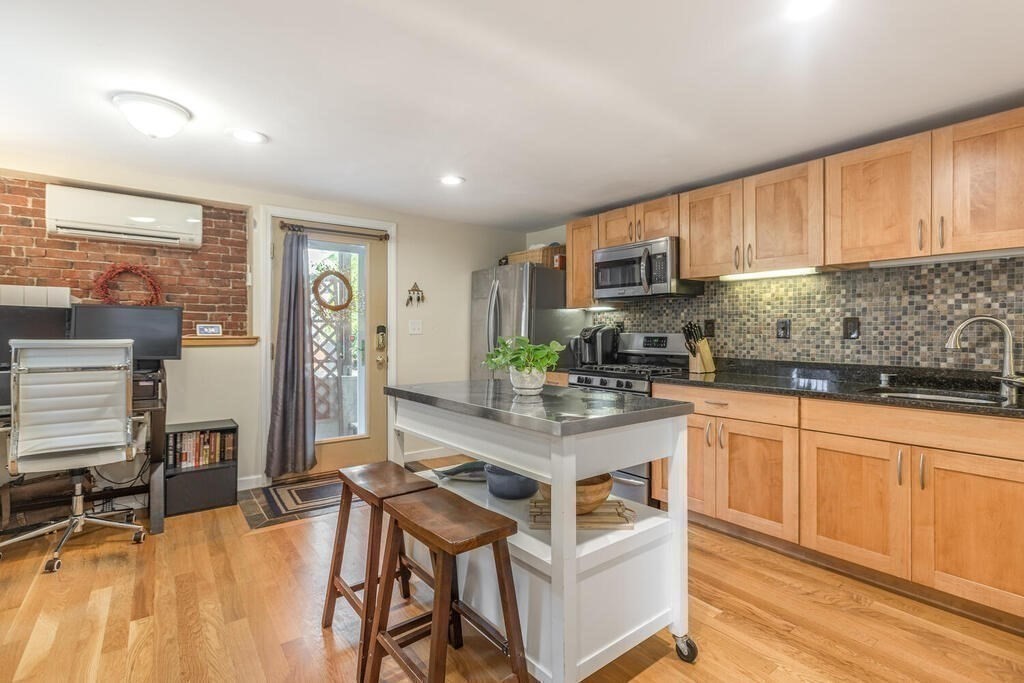 45 M Street Boston, MA 02127 - Photo 27 of 42 a kitchen with stainless steel appliances granite countertop a stove a sink dishwasher and a refrigerator with wooden cabinets