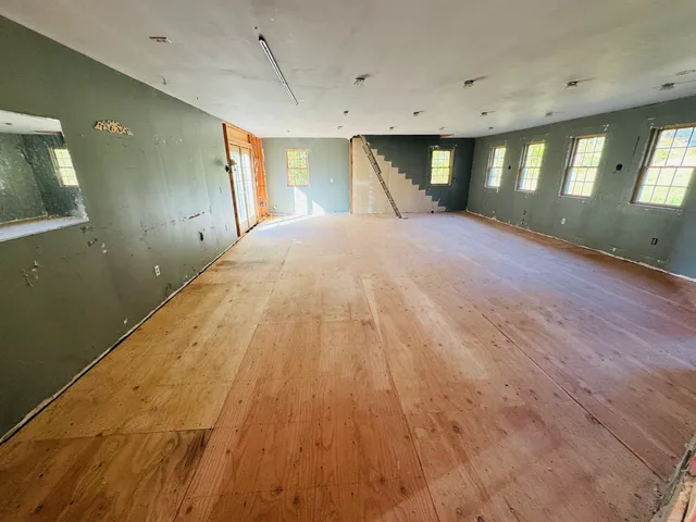 a spacious bedroom with a bed and a mirror on dresser