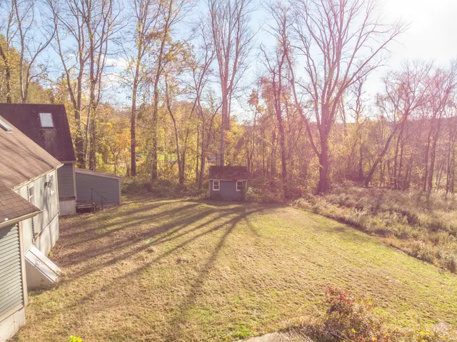 a view of yard with swimming pool and trees