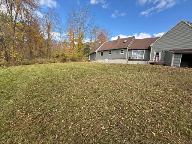 a front view of a house with yard and trees