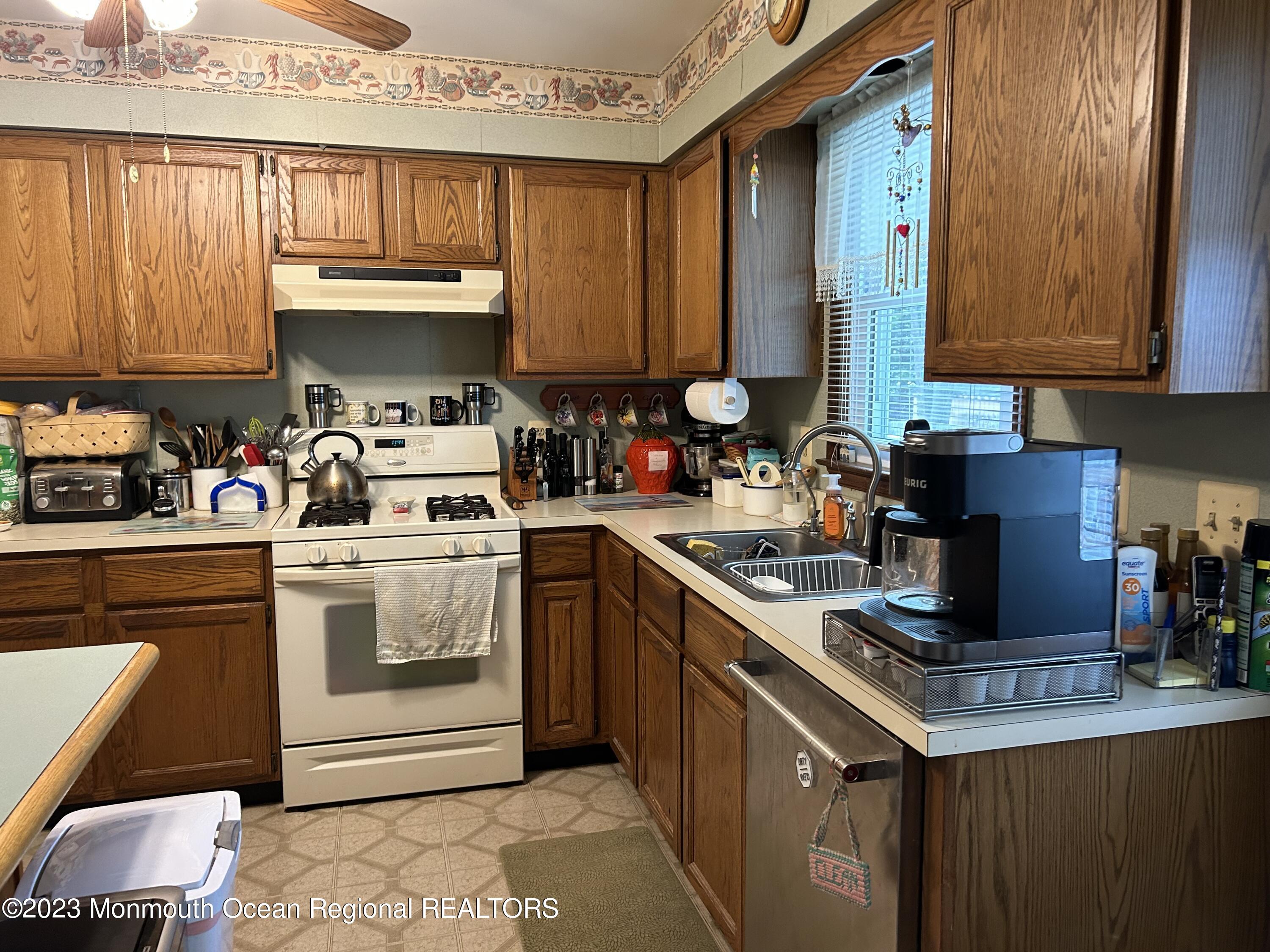 1635 Burrsville Road Brick, NJ 08724 - Photo 7 of 15 a kitchen with stainless steel appliances granite countertop a stove a sink dishwasher and cabinets with wooden floor