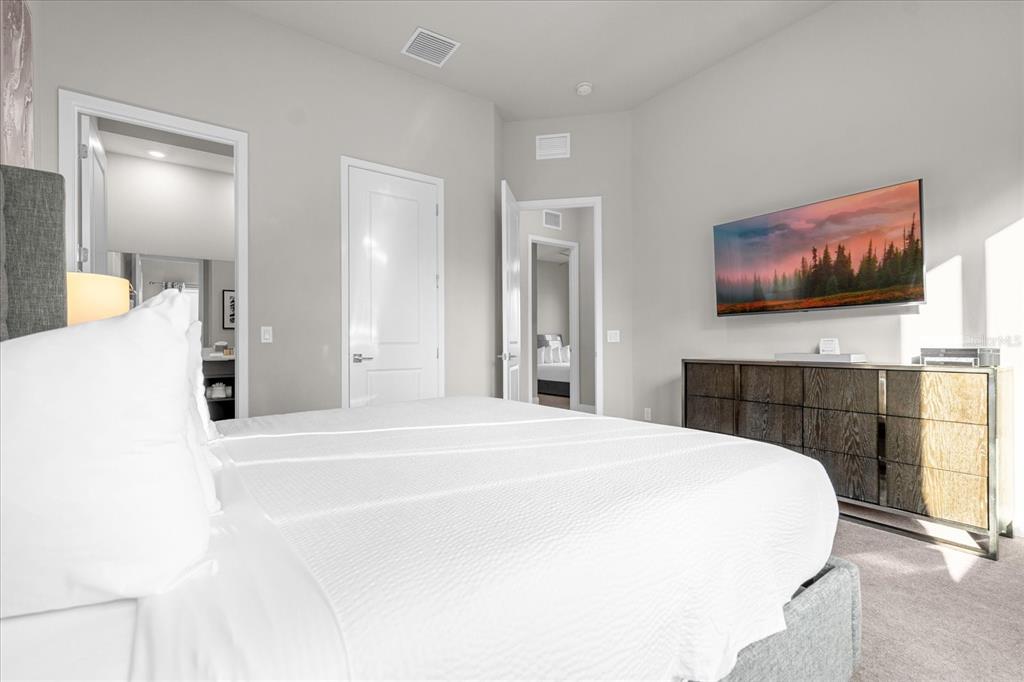 7770 Sandy Ridge Drive, Unit 227 Reunion, FL 34747 - Photo 12 of 33 a bedroom with a bed and a flat screen tv