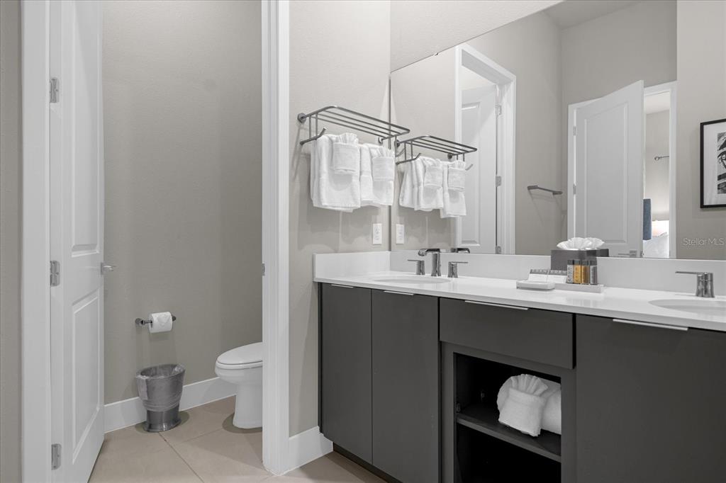 7770 Sandy Ridge Drive, Unit 227 Reunion, FL 34747 - Photo 14 of 33 a bathroom with a sink a toilet a mirror and shower