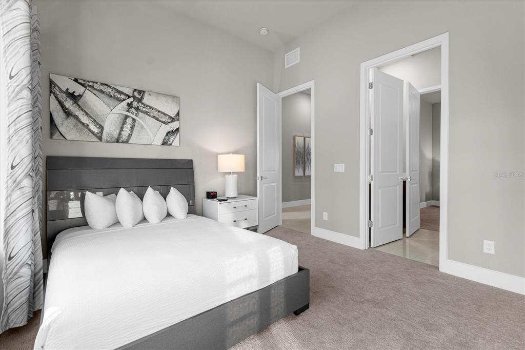 7770 Sandy Ridge Drive, Unit 227 Reunion, FL 34747 - Photo 17 of 33 a bedroom with a large bed and a chandelier