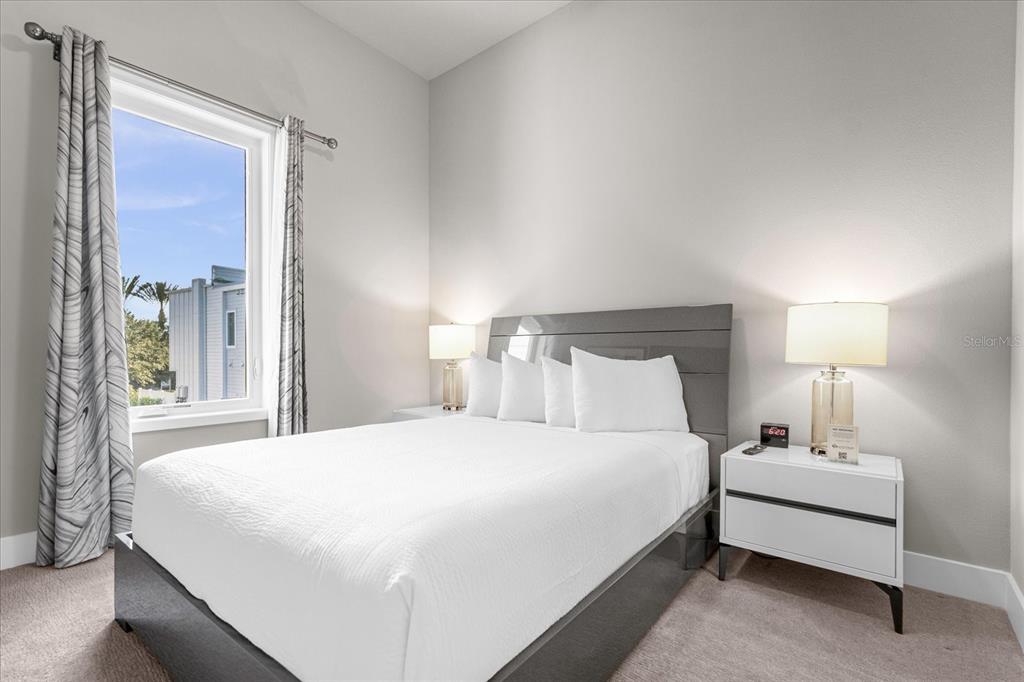 7770 Sandy Ridge Drive, Unit 227 Reunion, FL 34747 - Photo 22 of 33 a bedroom with a bed lamp and a large window