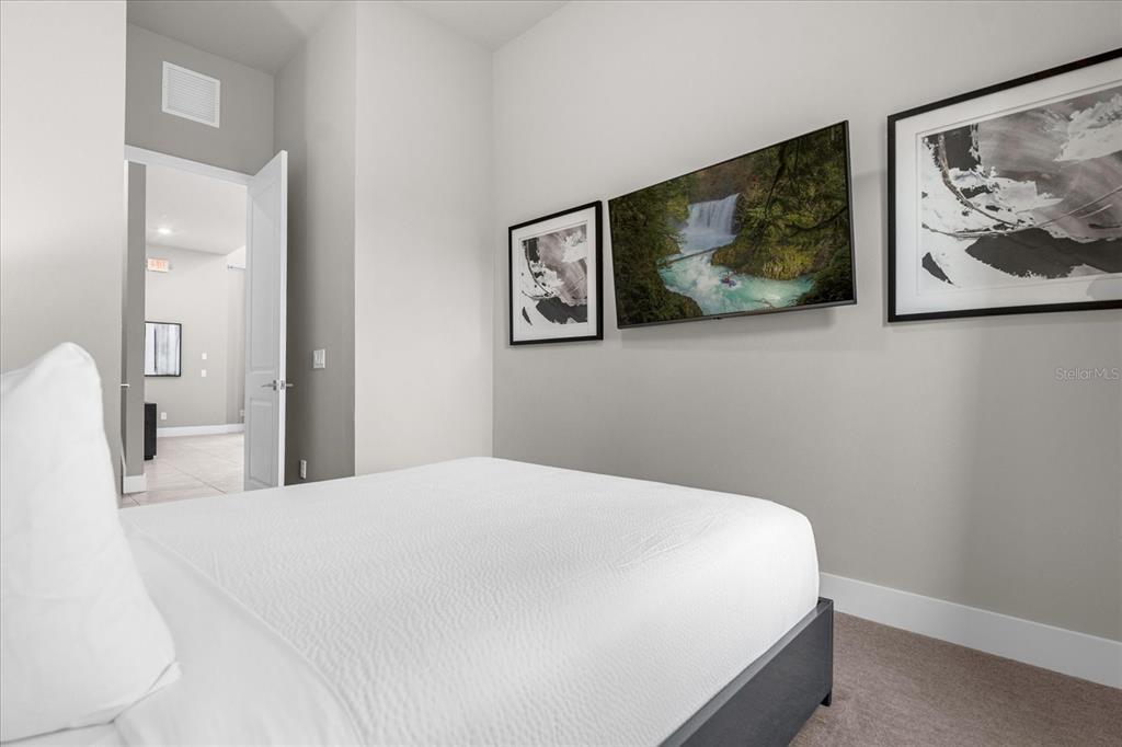 7770 Sandy Ridge Drive, Unit 227 Reunion, FL 34747 - Photo 23 of 33 a bedroom with a bed and painting on the wall