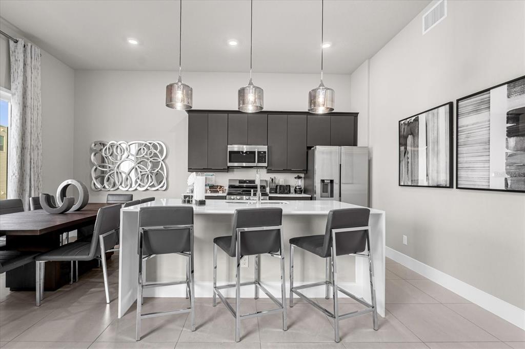 7770 Sandy Ridge Drive, Unit 227 Reunion, FL 34747 - Photo 8 of 33 a kitchen with kitchen island granite countertop a sink counter and chairs