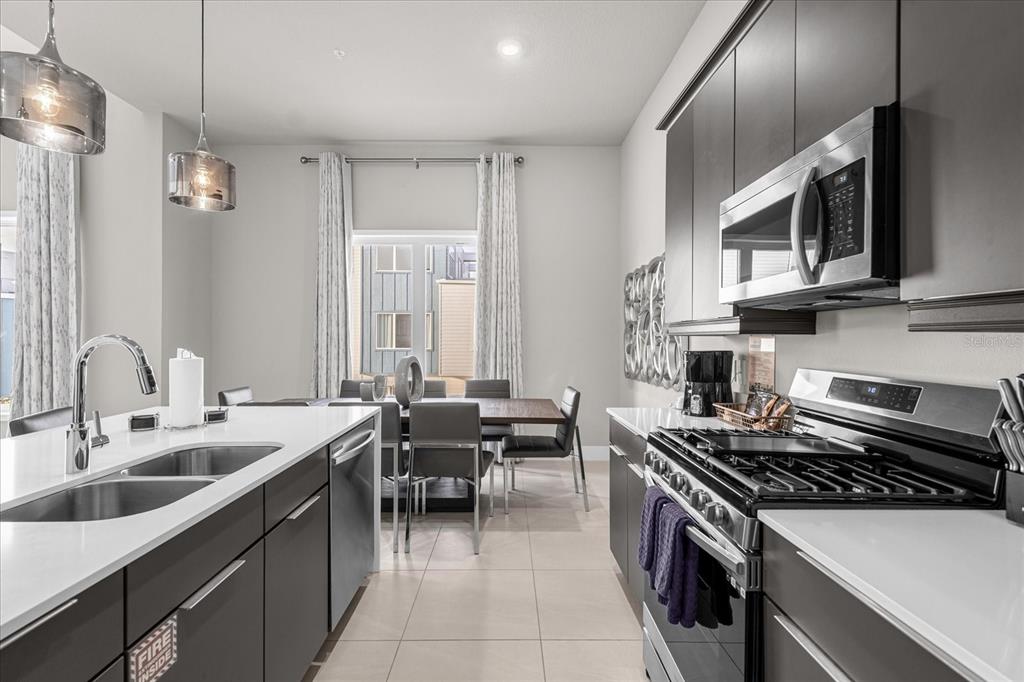 7770 Sandy Ridge Drive, Unit 227 Reunion, FL 34747 - Photo 9 of 33 a kitchen with stainless steel appliances a sink stove and cabinets