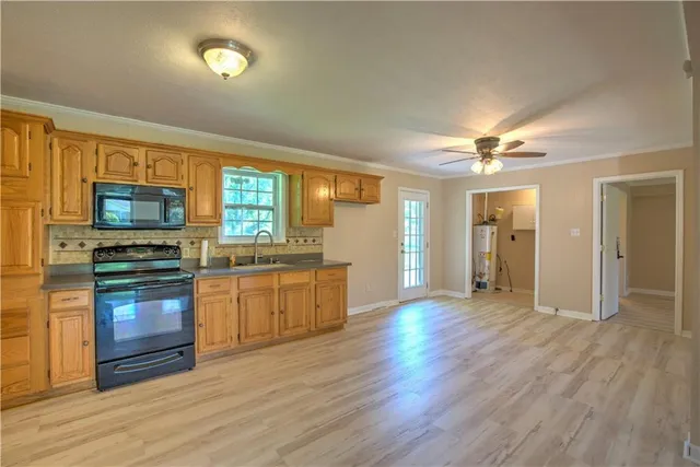 a view of a kitchen with a sink stove cabinets and empty room