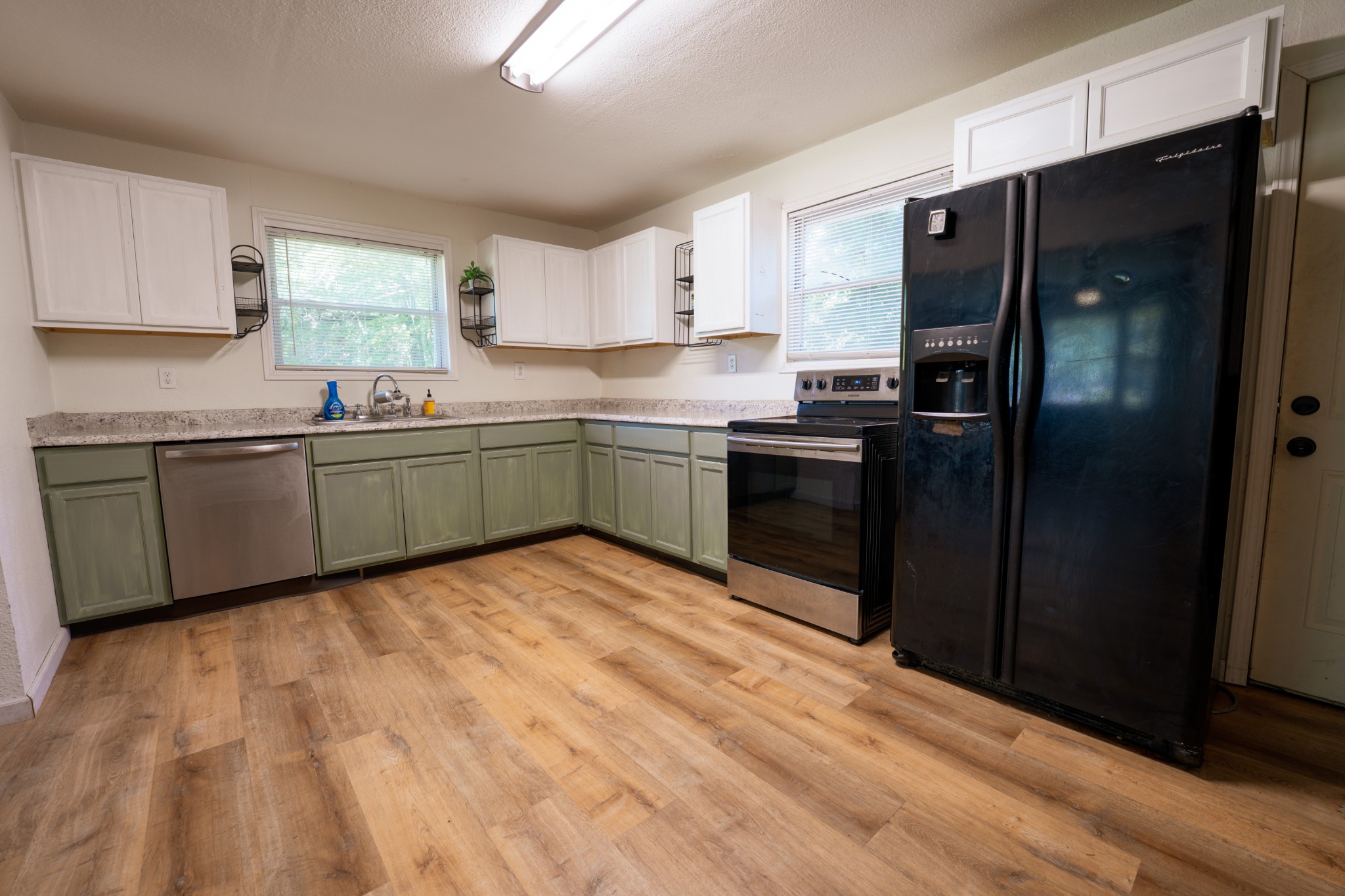 8247 Pinewood Road Nunnelly, TN 37137 - Photo 6 of 14 a kitchen with stainless steel appliances granite countertop a refrigerator and a sink