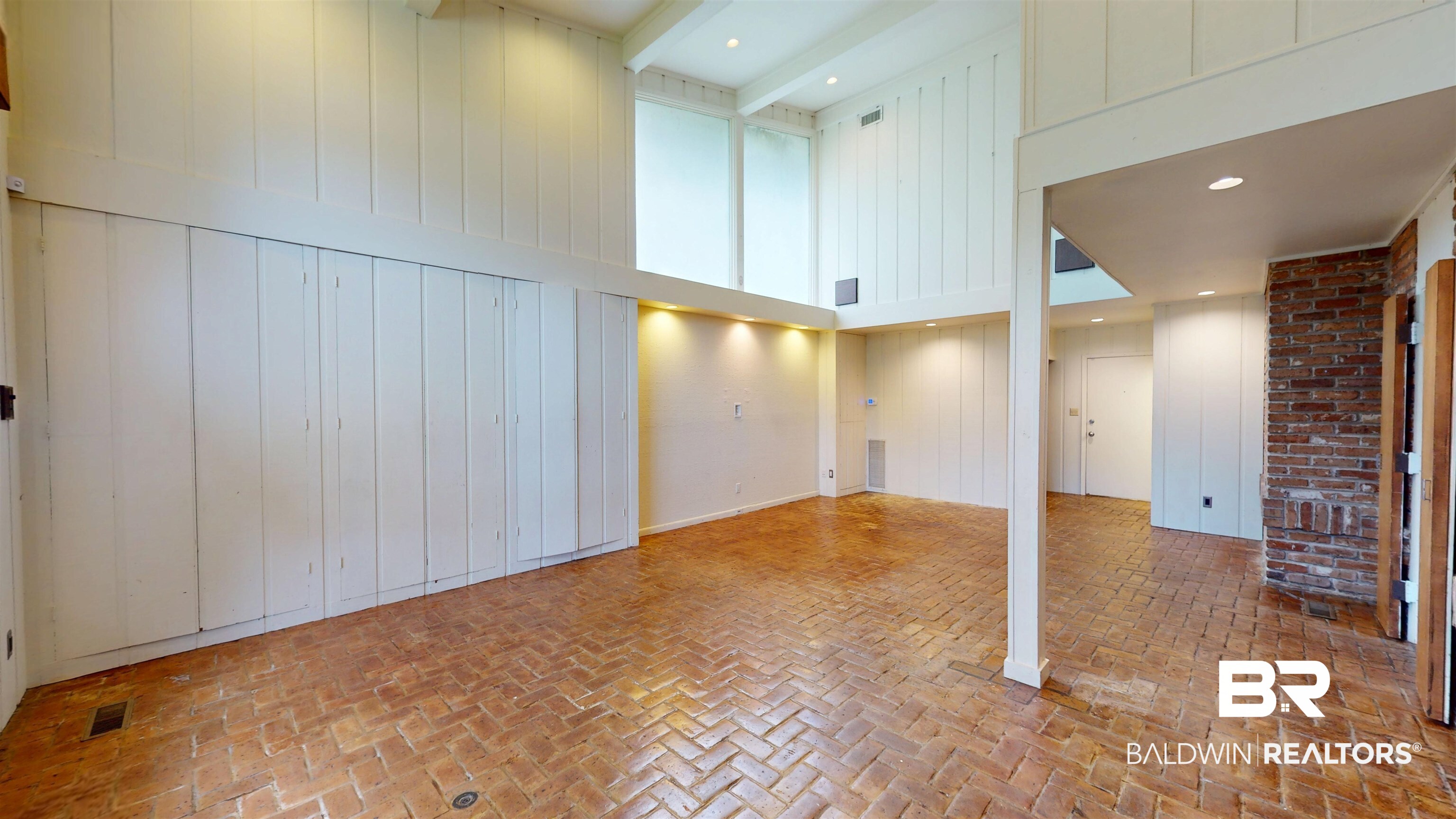 15 Spring Bank Road Mobile, AL 36608 - Photo 31 of 58 Unfurnished great room featuring brick floors, wood walls, and a towering ceiling
