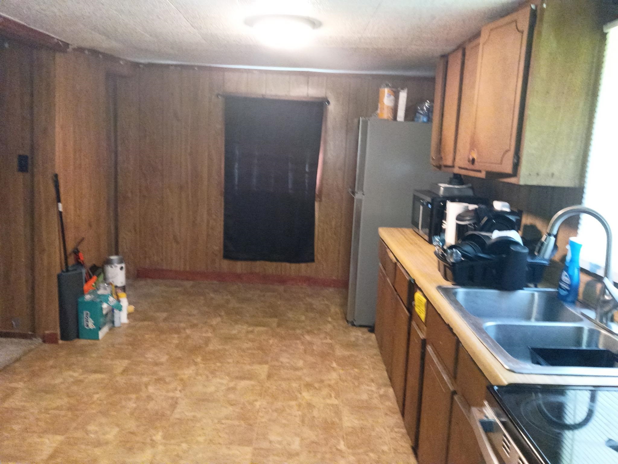 180 Barbee Avenue Ripley, TN 38063 - Photo 12 of 13 Kitchen with wood-finish paneling, vinyl tile flooring, and a window