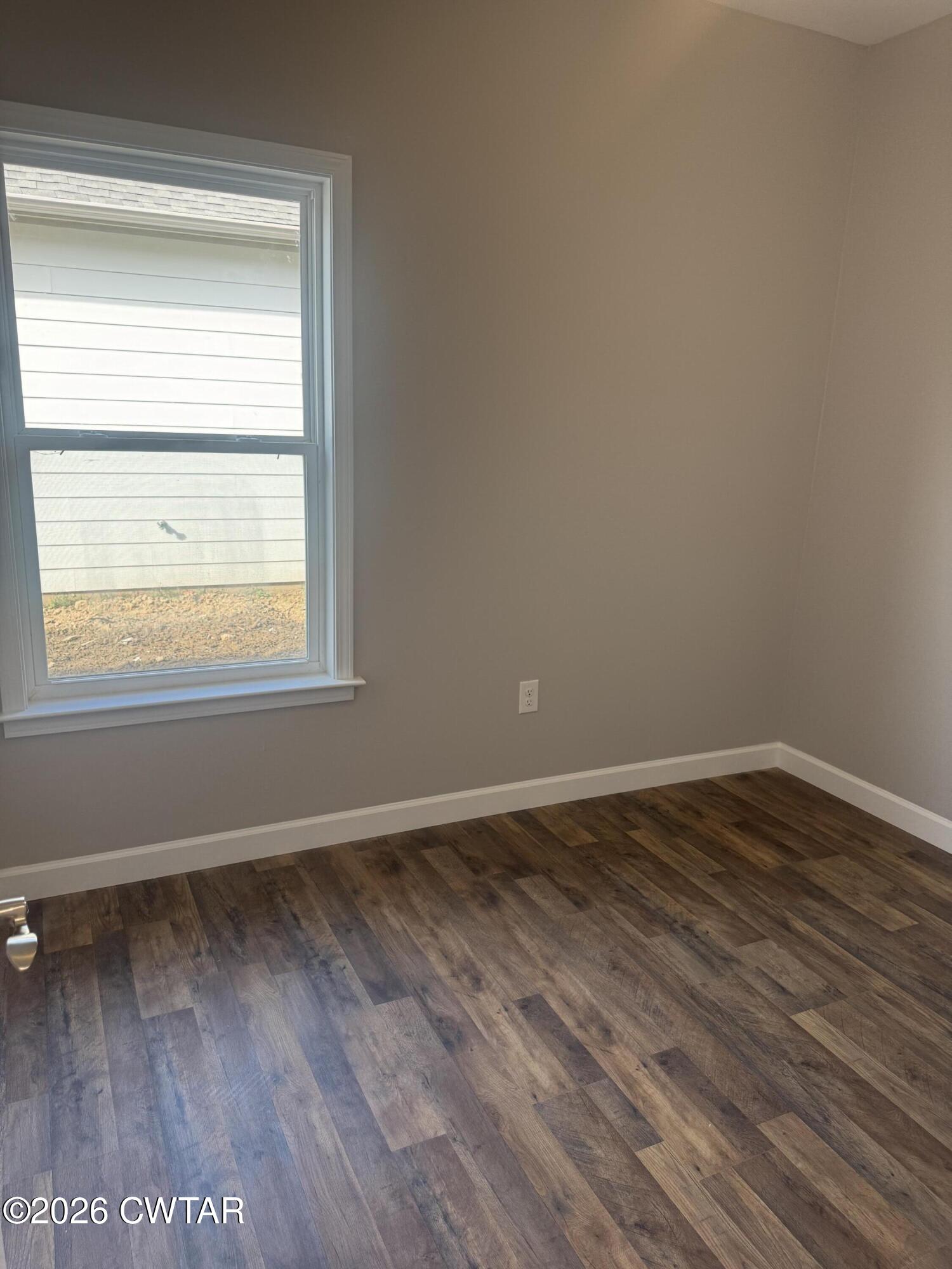 103 Dempster Street Jackson, TN 38301 - Photo 13 of 18 a view of an empty room with wooden floor and a window