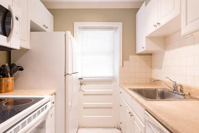 a living room with furniture a flat screen tv and a window