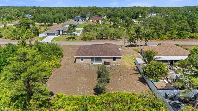 an aerial view of residential houses with outdoor space and trees
