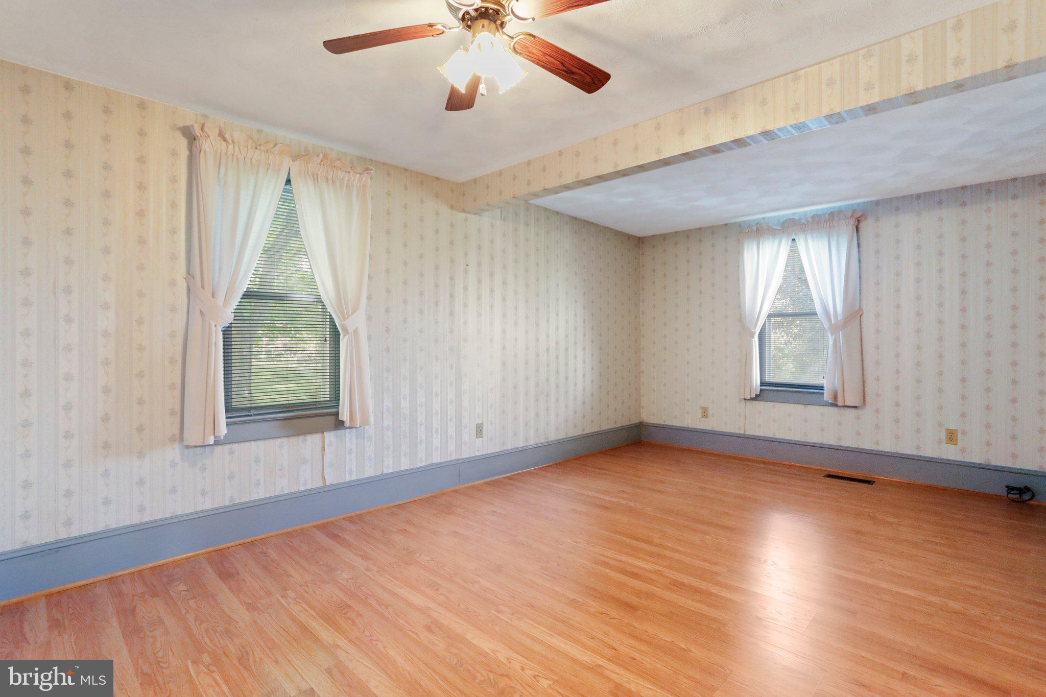 1477 Clearview Road Luray, VA 22835 - Photo 11 of 39 an empty room with wooden floor chandelier fan and windows