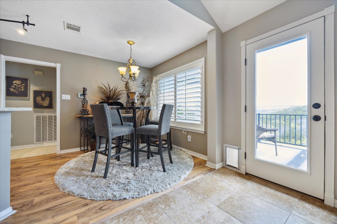 515 Wesley Ridge Drive Spicewood, TX 78669 - Photo 13 of 36 a dining room with furniture a chandelier and wooden floor