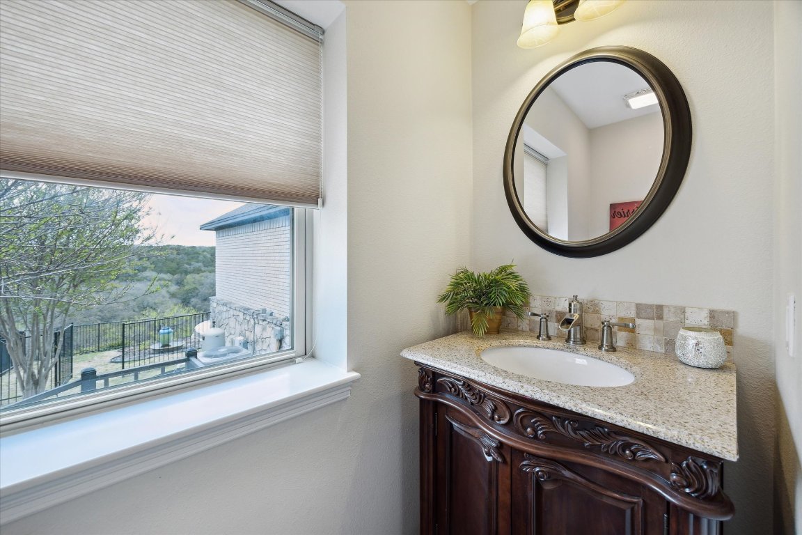 515 Wesley Ridge Drive Spicewood, TX 78669 - Photo 14 of 36 a bathroom with a granite countertop sink and a mirror