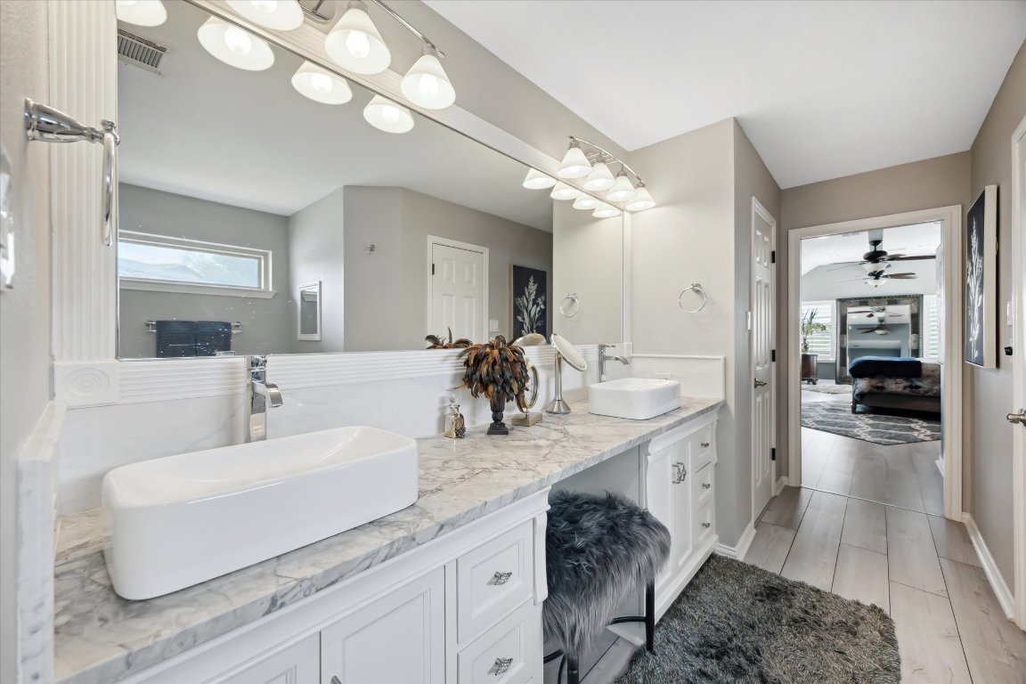 515 Wesley Ridge Drive Spicewood, TX 78669 - Photo 18 of 36 a bathroom with a sink double vanity and a mirror