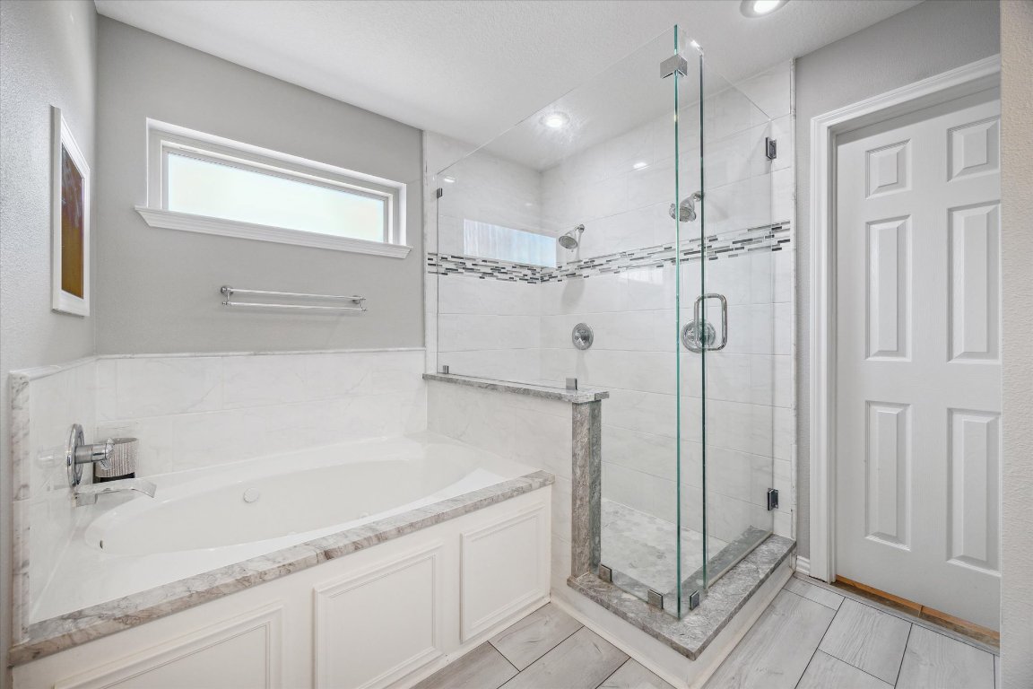 515 Wesley Ridge Drive Spicewood, TX 78669 - Photo 19 of 36 a bathroom with a bathtub and a shower