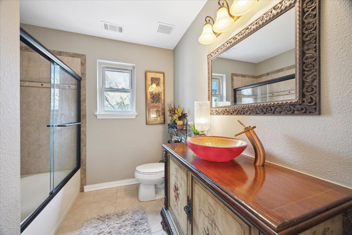 515 Wesley Ridge Drive Spicewood, TX 78669 - Photo 25 of 36 a bath room with a toilet and a window