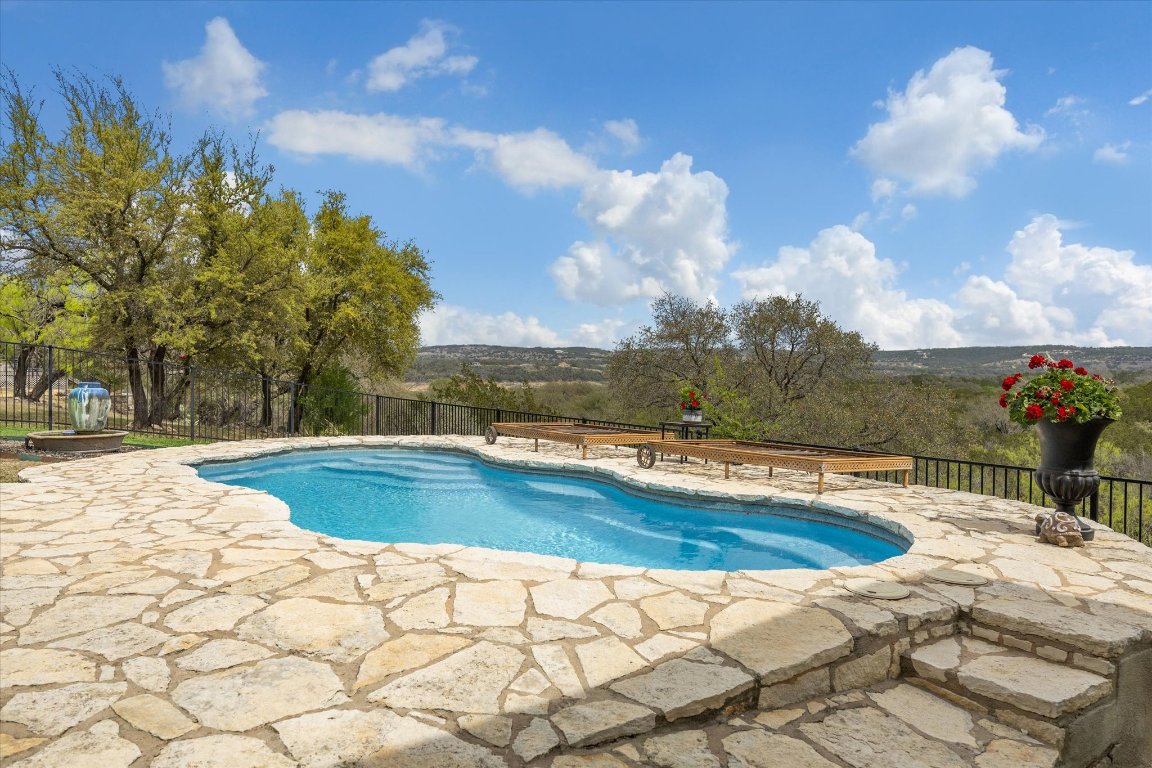 515 Wesley Ridge Drive Spicewood, TX 78669 - Photo 30 of 36 a view of a swimming pool with a lounge chairs