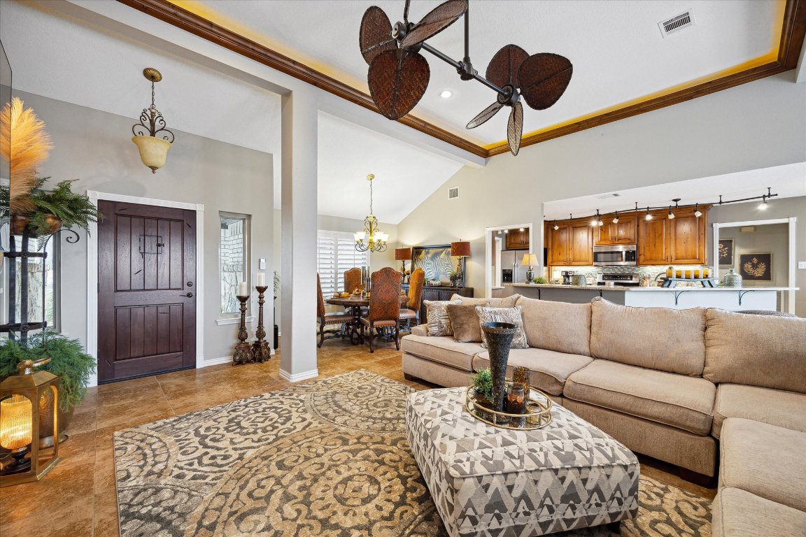 515 Wesley Ridge Drive Spicewood, TX 78669 - Photo 6 of 36 a living room with furniture kitchen view and a chandelier
