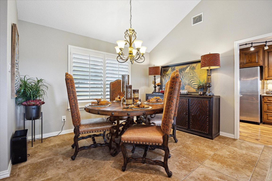 515 Wesley Ridge Drive Spicewood, TX 78669 - Photo 9 of 36 a view of a dining room with furniture and chandelier