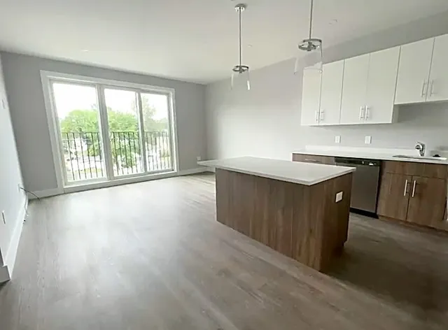a large kitchen with a wooden floor and stainless steel appliances