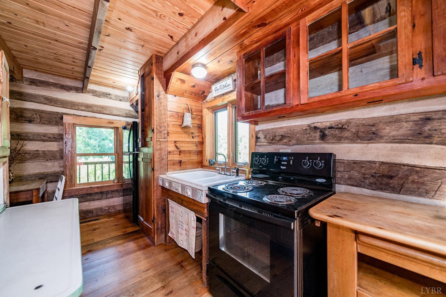 704 Peters Hollow Road Monroe, VA 24574 - Photo 17 of 55 a kitchen with stainless steel appliances granite countertop a stove and a wooden cabinets
