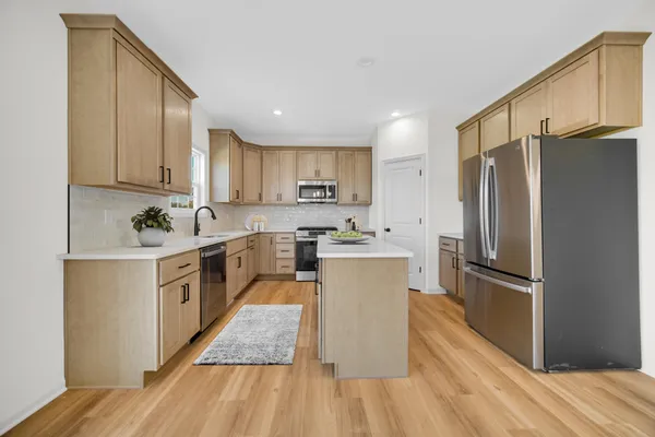 a kitchen with a refrigerator sink and wooden cabinets