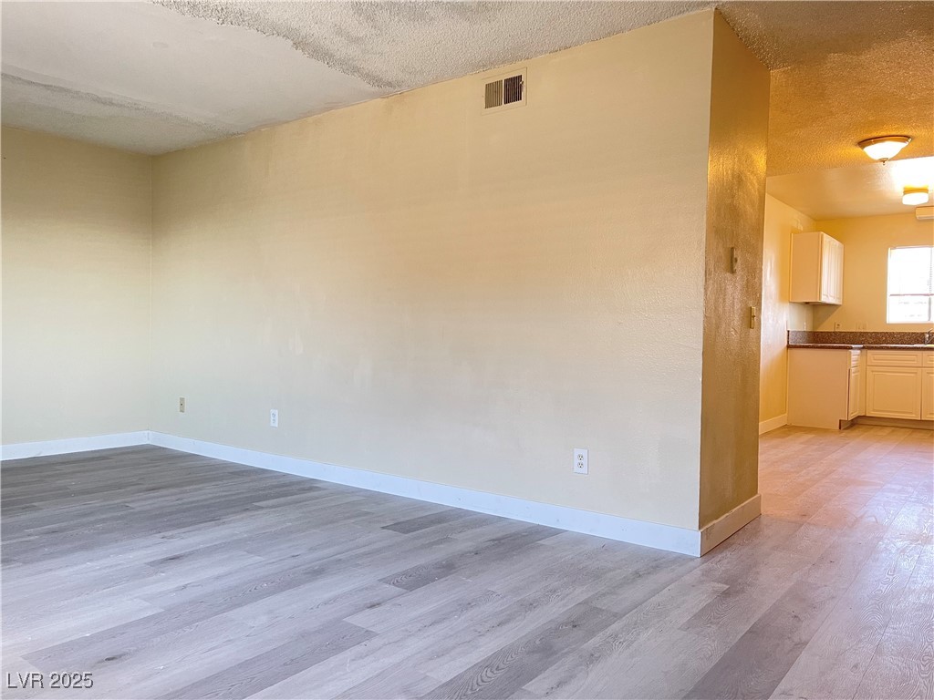 1709 Fairfield Avenue, Unit G Las Vegas, NV 89102 - Photo 6 of 15 Spare room featuring light wood-type flooring and a textured ceiling