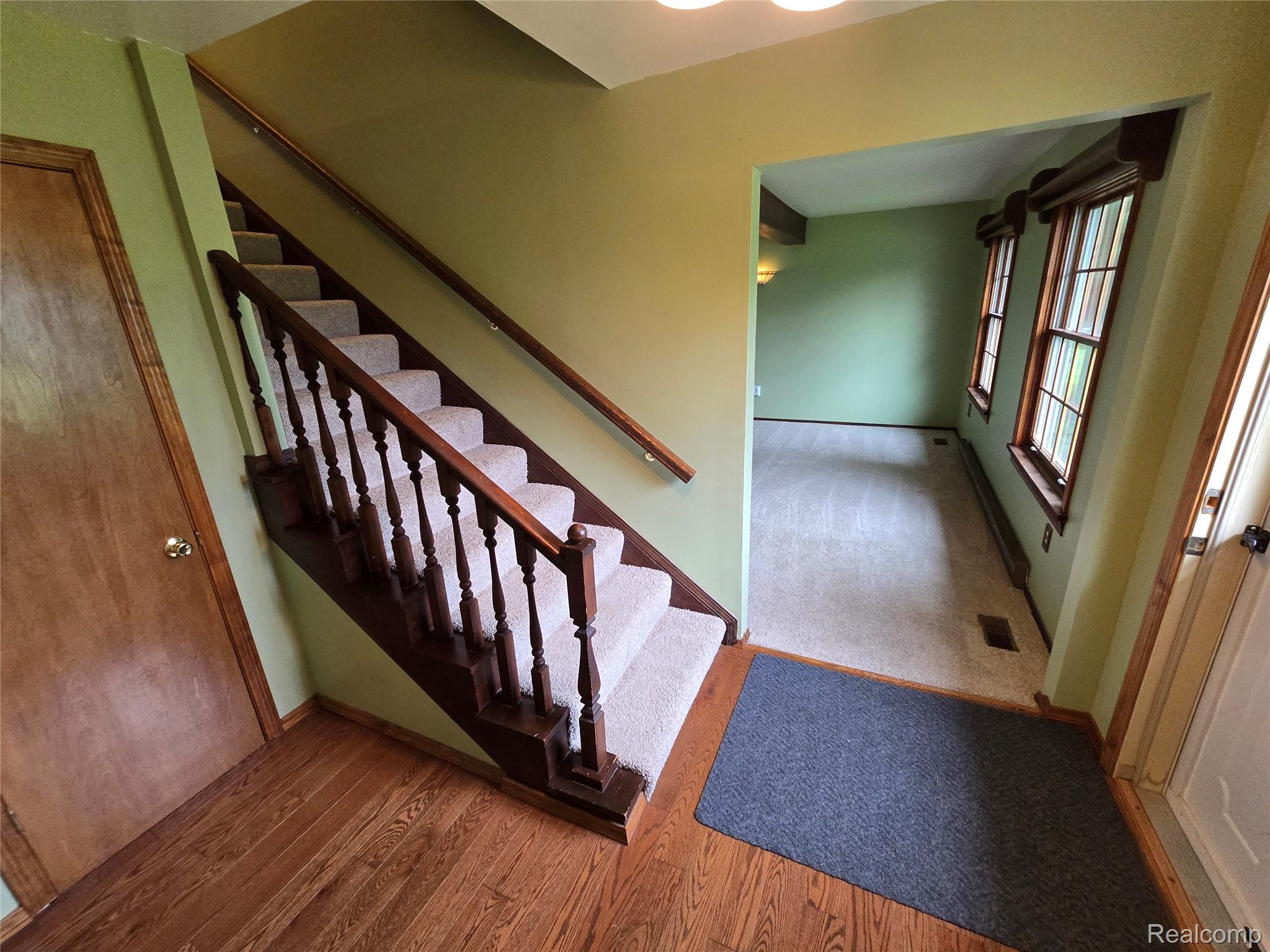 5282 McIntyre Road North Street, MI 48049 - Photo 11 of 53 Hardwood flooring, carpeted stairs with wood railing, recessed lighting, and two multi-pane windows