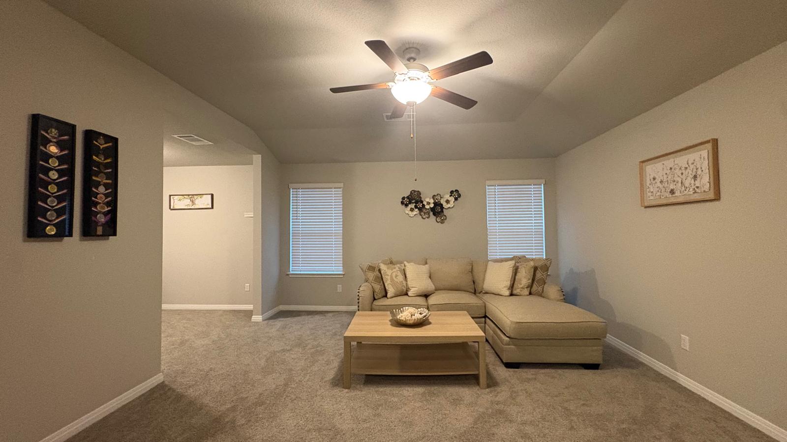 6511 Dragride Road Buda, TX 78610 - Photo 23 of 36 Plush carpet and a tray ceiling create a cozy living space, perfect for relaxation.