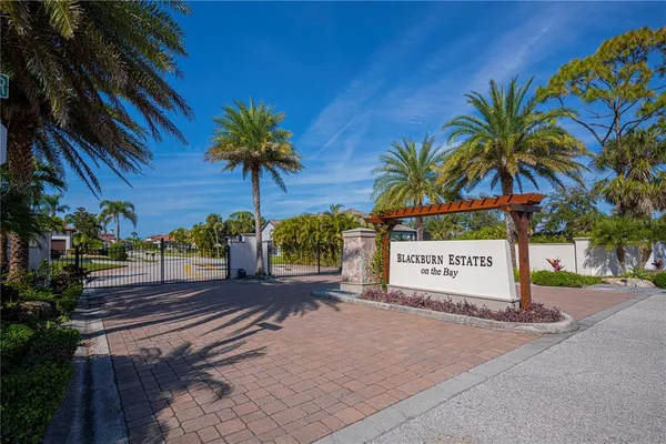 a sign board with flower plants and wooden fence
