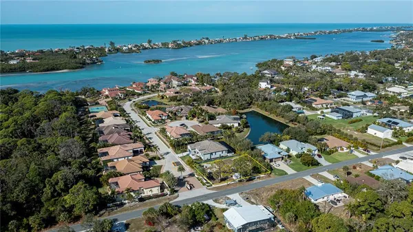 an aerial view of ocean and residential houses with outdoor space