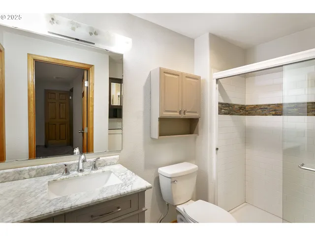 a bathroom with a sink toilet a mirror and shower