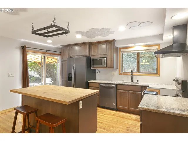 a kitchen with stainless steel appliances granite countertop a sink stove and refrigerator