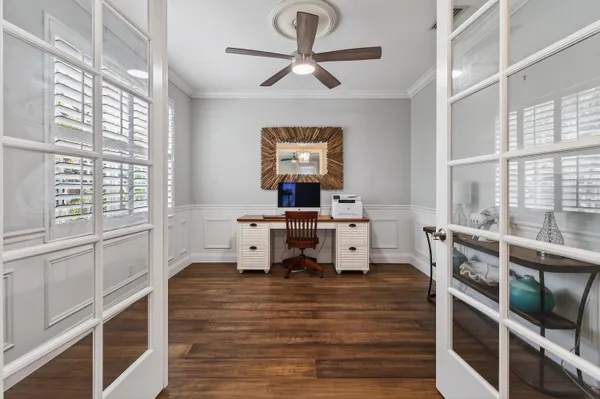 a view of a livingroom with wooden floor and a ceiling fan