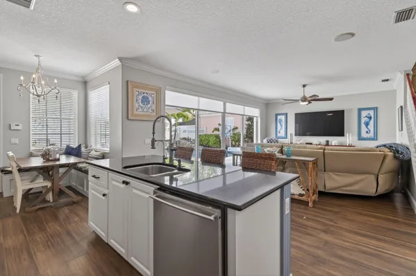 a view of a dining room with furniture a chandelier and wooden floor