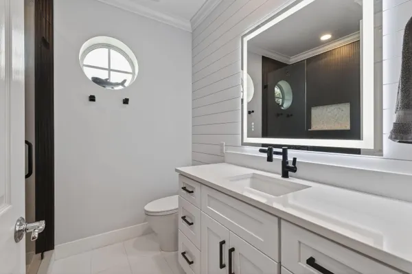 a bedroom with a bed and a flat tv screen on dresser