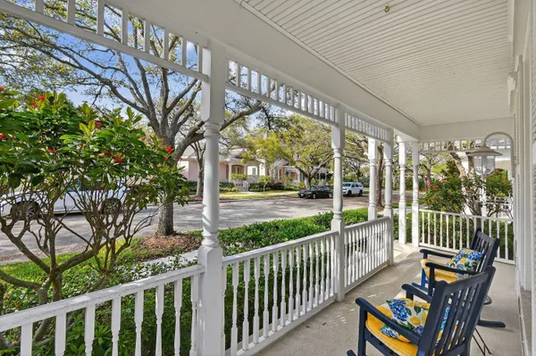 a view of a porch with chairs and wooden fence