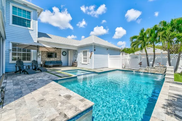 a view of a house with backyard and sitting area