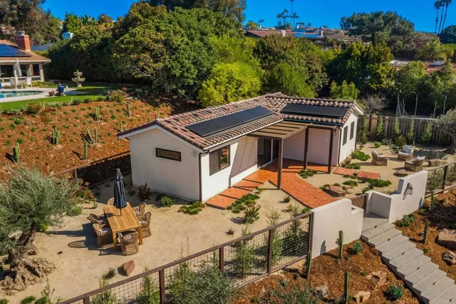 a view of a house with backyard sitting area and garden