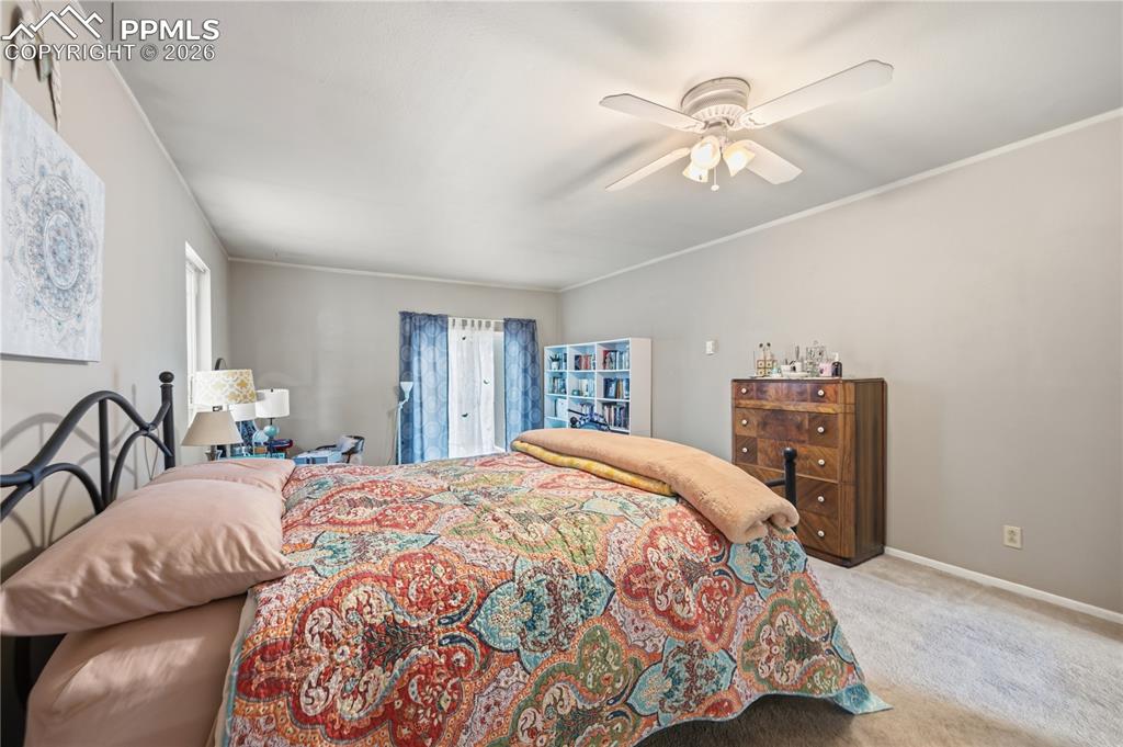 5130 Neeper Valley Road Manitou Springs, CO 80829 - Photo 16 of 38 a bedroom with a large bed and a chandelier