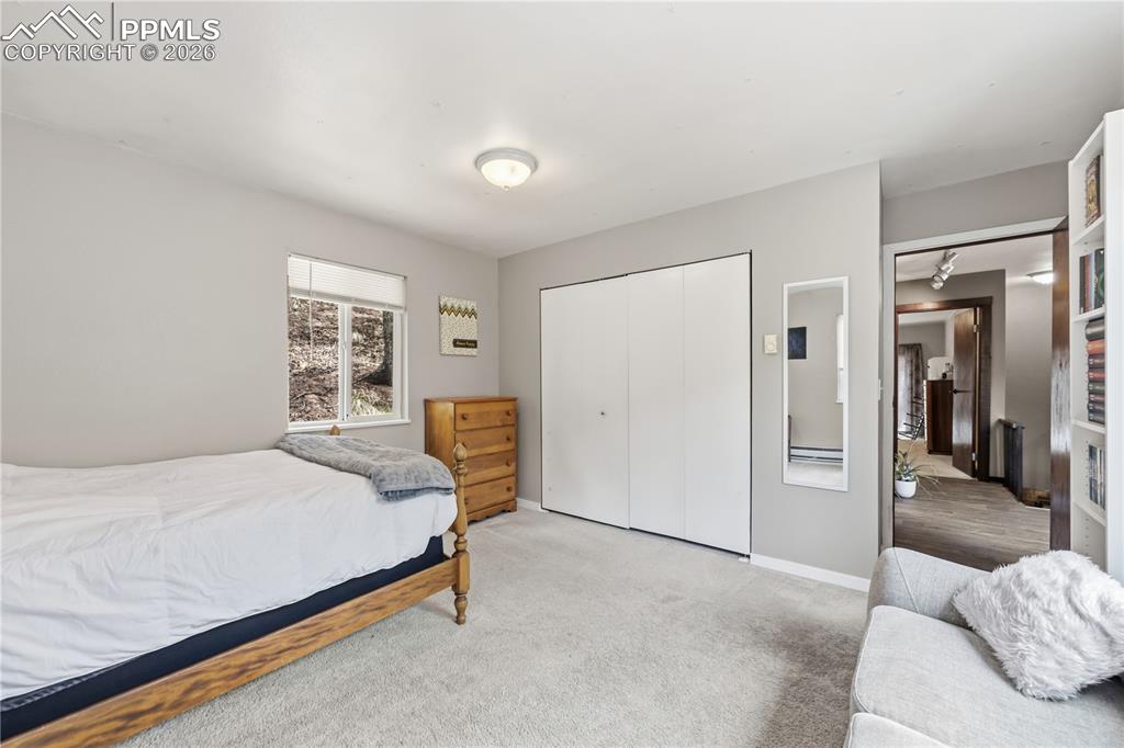 5130 Neeper Valley Road Manitou Springs, CO 80829 - Photo 20 of 38 a bedroom with a bed and a couch
