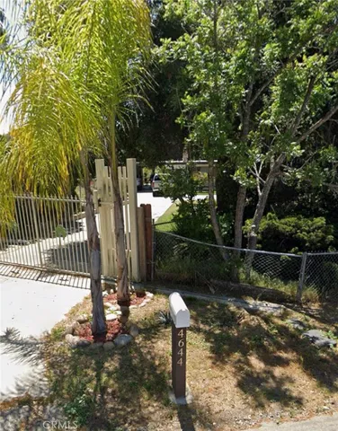 a backyard of a house with lots of green space and fountain