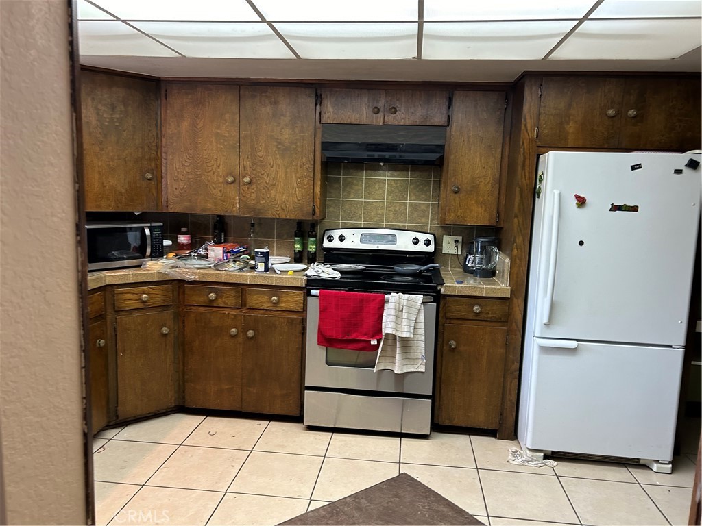 4644 La Canada Road Fallbrook, CA 92028 - Photo 21 of 26 a kitchen with stainless steel appliances granite countertop a refrigerator and a stove