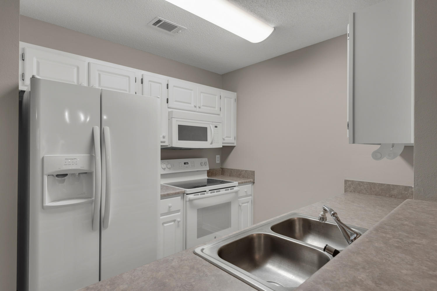 212 Tooke Street, Unit A Fort Walton Beach, FL 32547 - Photo 5 of 26 a kitchen with white cabinets and stainless steel appliances