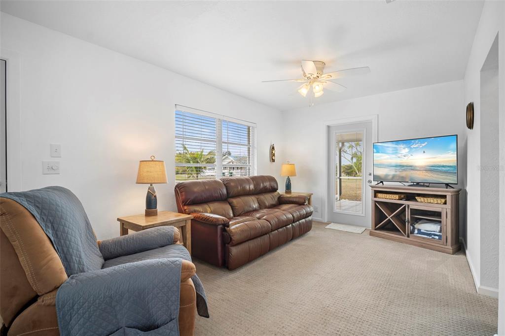 29098 Riverview Lane Punta Gorda, FL 33982 - Photo 5 of 35 a living room with furniture a flat screen tv and kitchen view